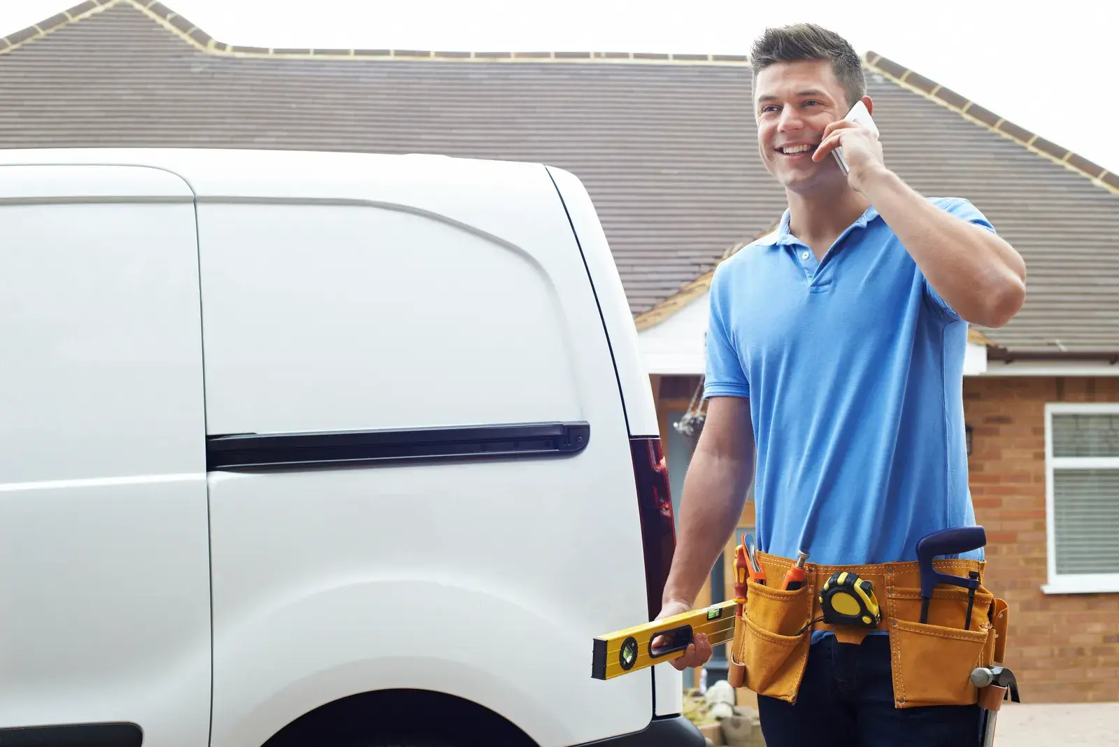 Home services contractor on the phone beside his van
